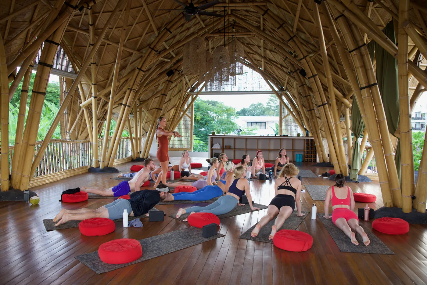 A mobility class on mats in the bamboo yoga shala at SYB's Bali retreat