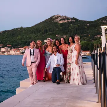 Friends dressed up on a stone pier at dusk on the SYB Croatia trip