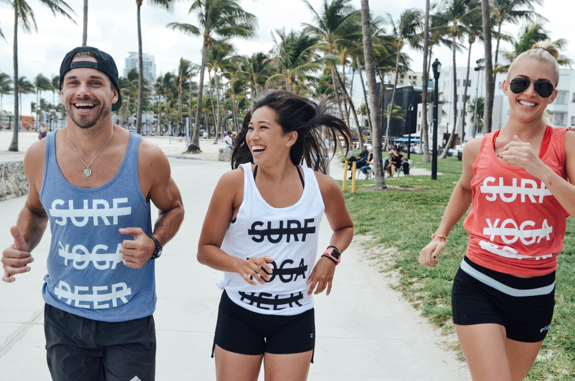 SYB crew running on the Miami Beach boardwalk, one in the white cross-out tank