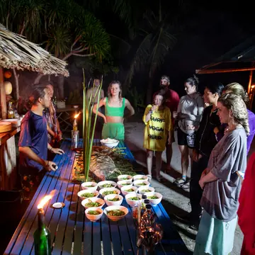 Dinner laid out by candlelight at a beach camp at night on the SYB Philippines trip