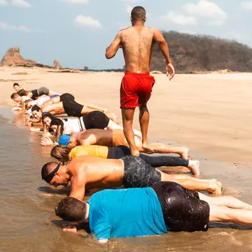 Beach workout with a row of planks at the edge of the water on the SYB Nicaragua Surf Camp trip