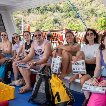 Friends sitting together on the boat with their bags on the SYB Philippines trip