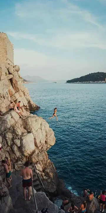 Jumping into the sea from the rocks below a tall cliff on the SYB Croatia trip