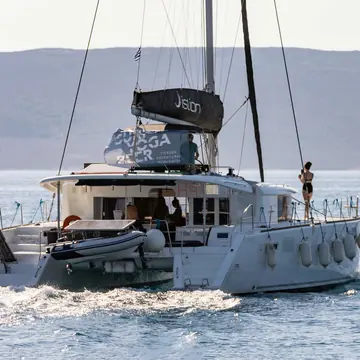 One of the catamarans under way with a crew member on deck on the SYB Greece trip