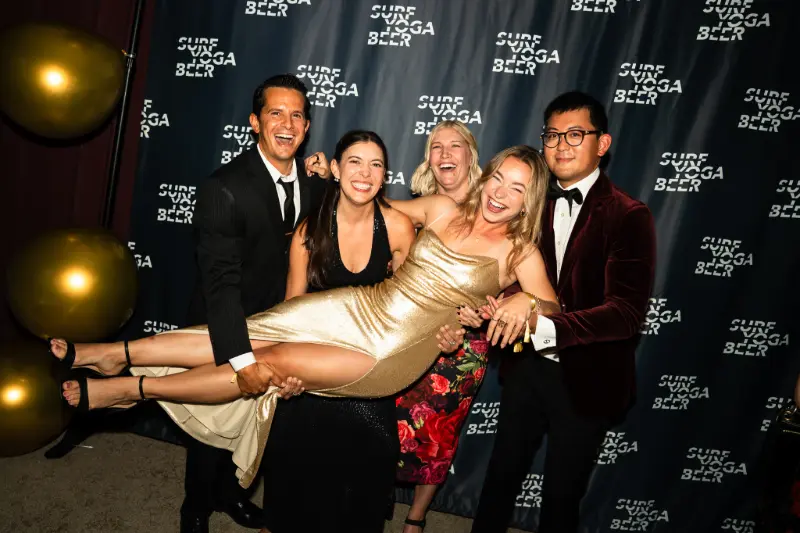 Guests carrying a friend sideways at the photo wall
