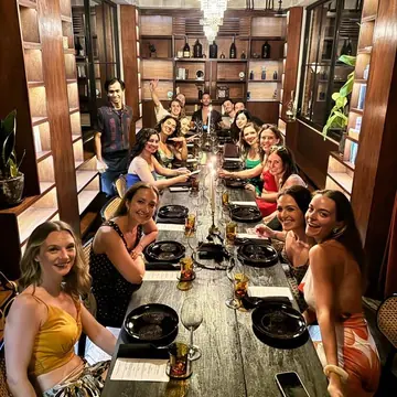 The group around a long dinner table under a chandelier on the SYB Bali trip