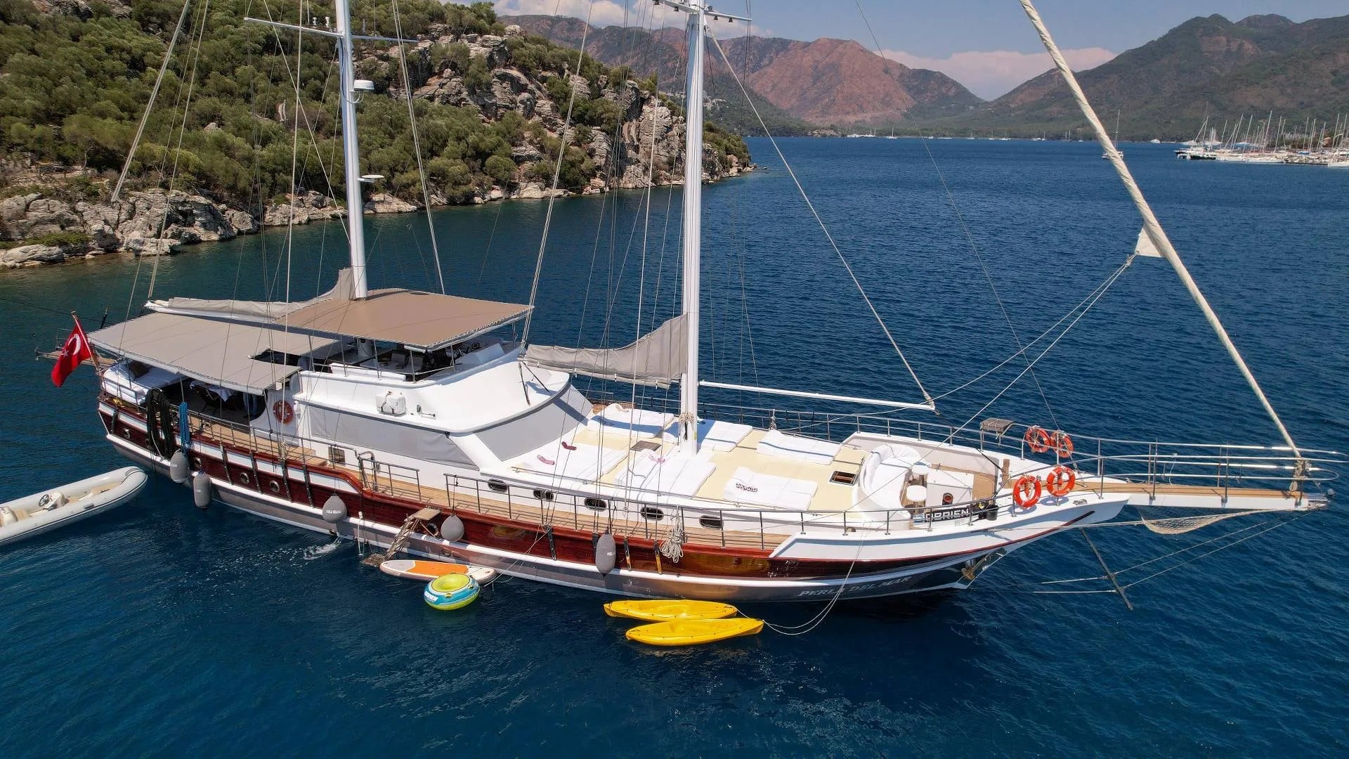 Drone shot of Perla del Mar at anchor with two kayaks floating next to the boat