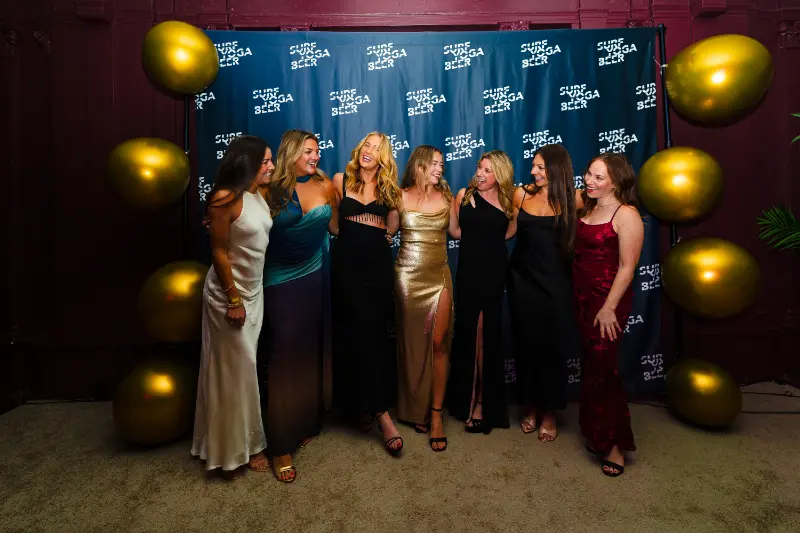 Friends in gold and silver gowns at the photo wall
