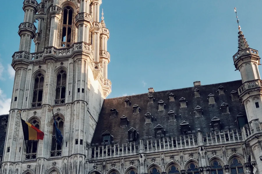 Brussels Grand Place town hall and Belgian flag, first-night stop on the Dash to Dubrovnik Europe road trip itinerary