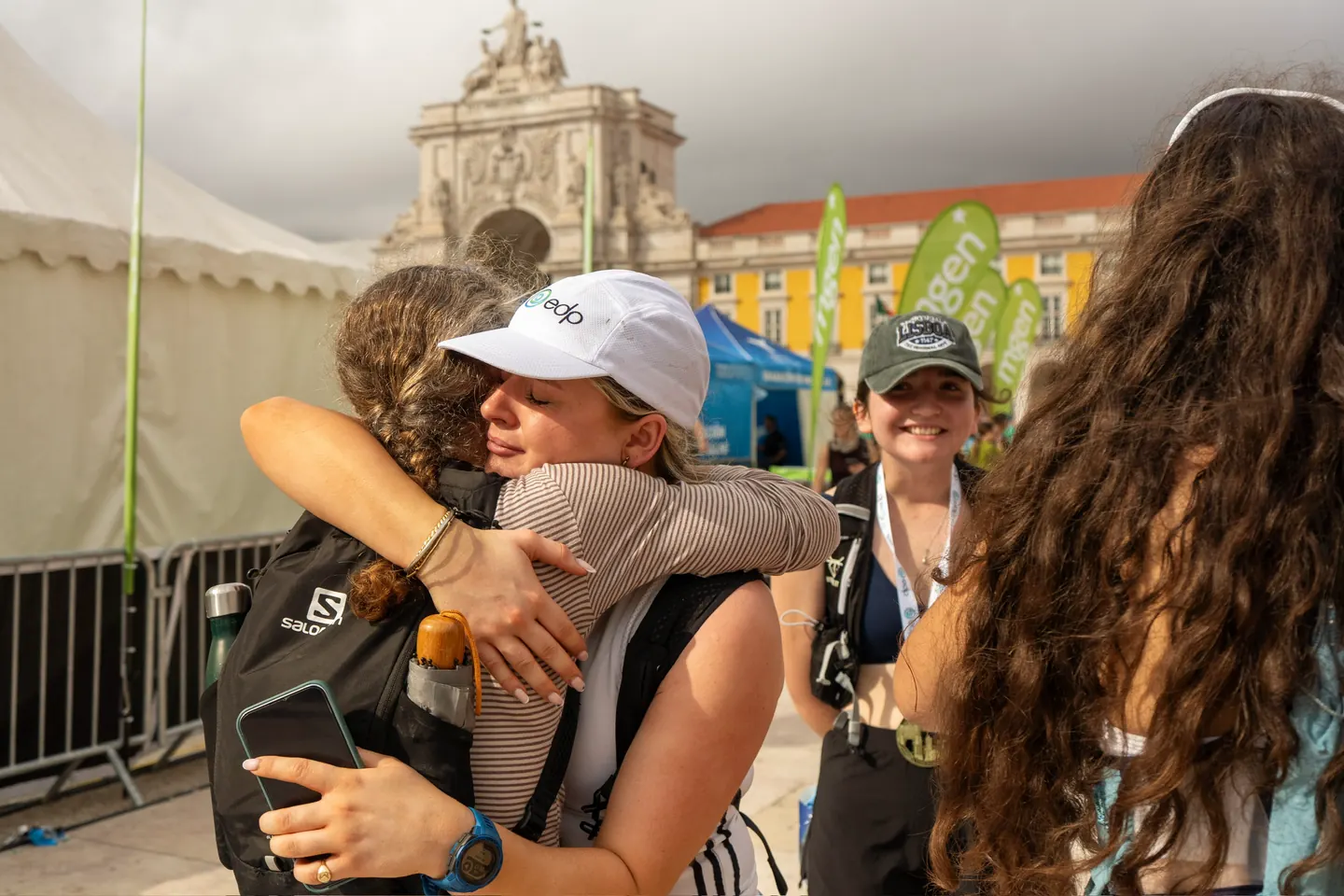 Two Hardest Adventures runners embracing at the Lisbon Marathon finish line after completing the race together.