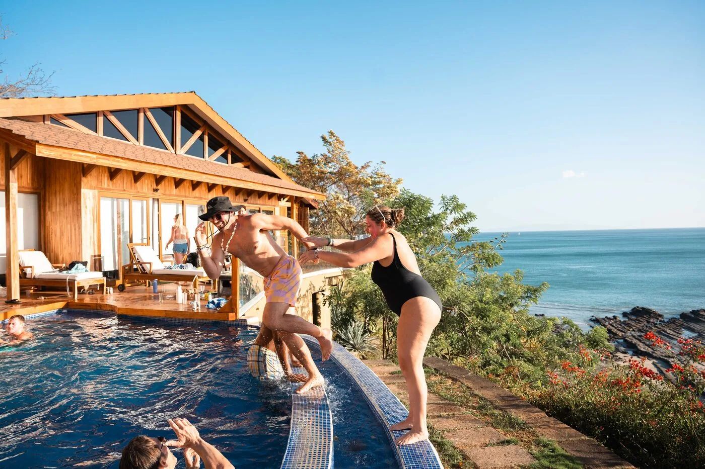 A traveler at the edge of a villa pool above the Pacific at Playa Maderas