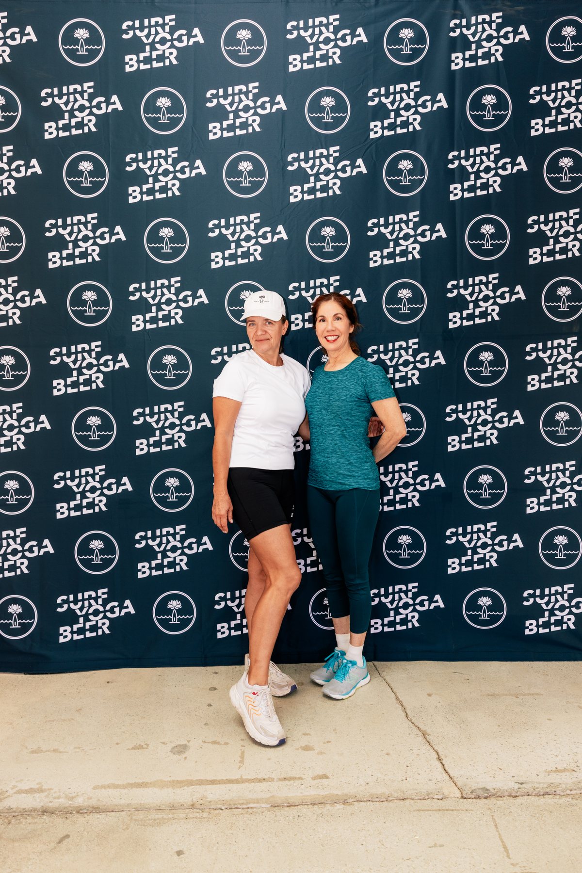 Two runners at the SurfYogaBeer backdrop