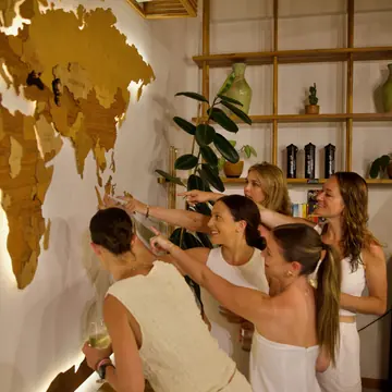 Friends in white pointing at a world map on the wall on the SYB Bali trip