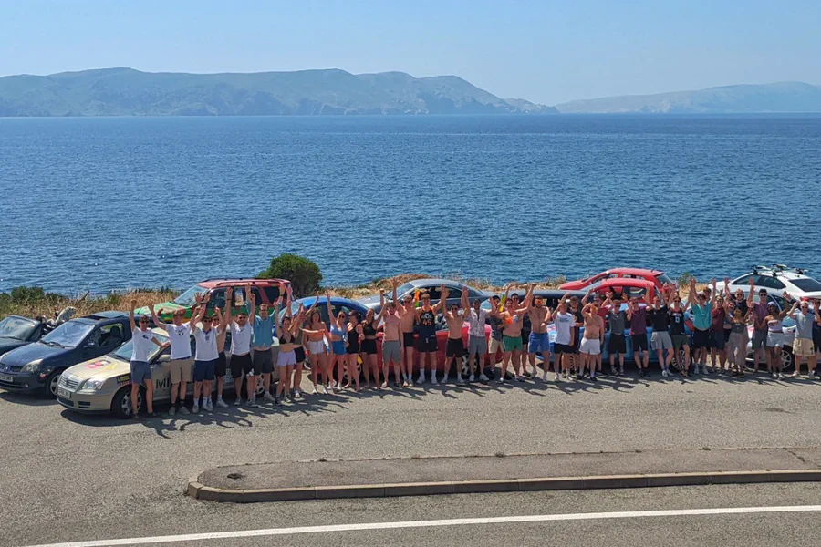 Dash to Dubrovnik group and their cars at a coastal viewpoint before the onward journey and backpacking Europe routes home