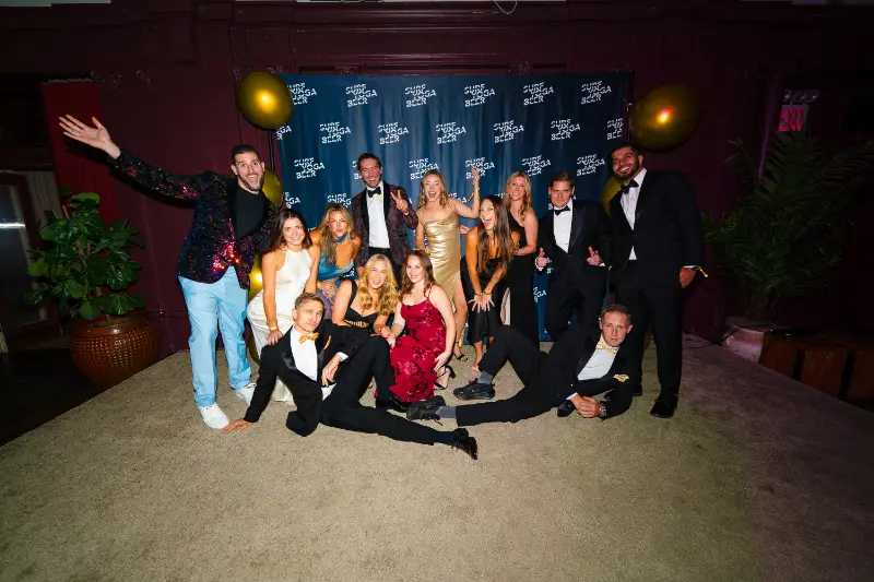 A big group posing on the floor at the photo wall