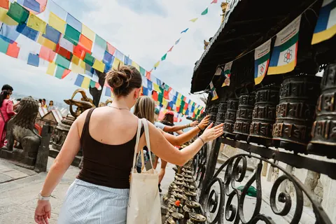 Hardest Adventures trekkers spinning the prayer wheels under the flags at Swayambhunath