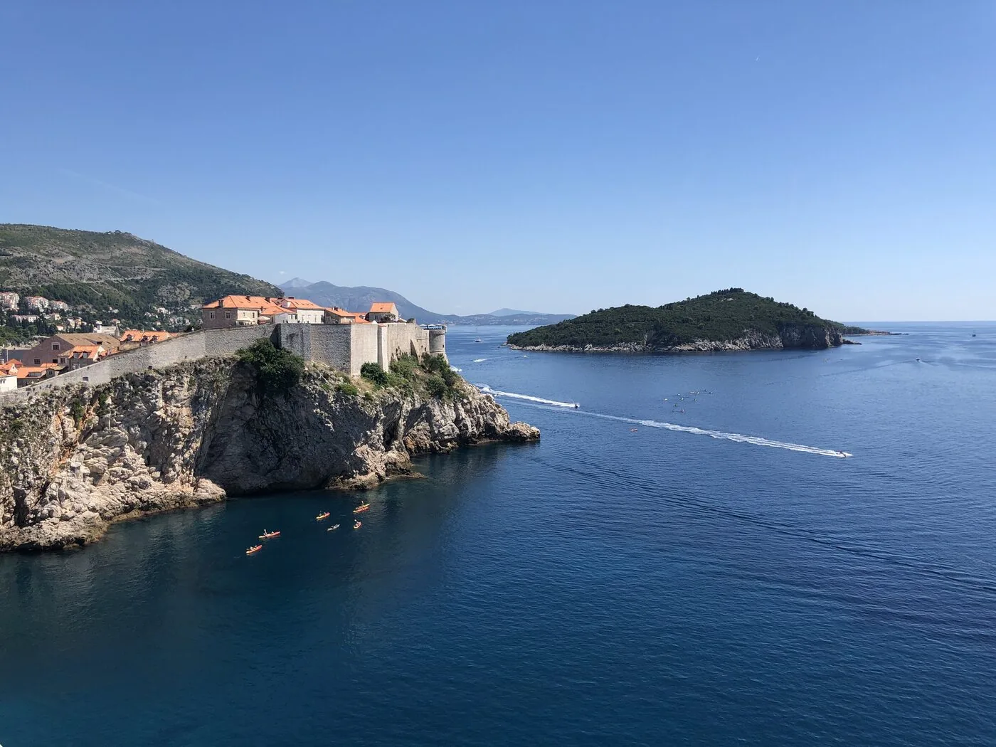 The old city walls of Dubrovnik on cliffs above the sea