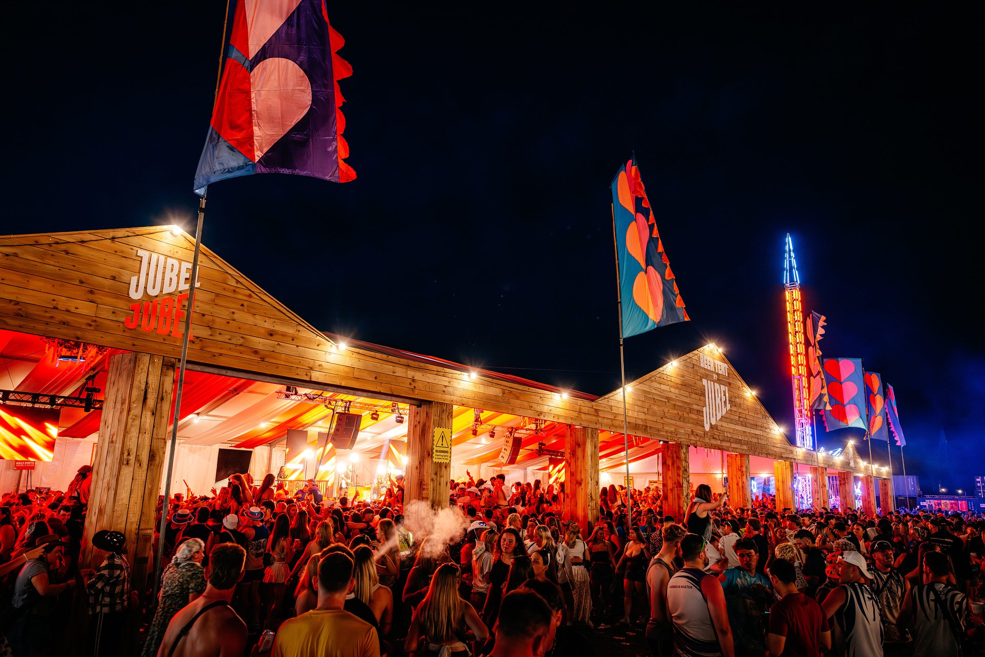 Beer Tent by Jubel festival music arena at night with a large crowd for the Friday Opening Party, at Bournemouth 7s Festival.