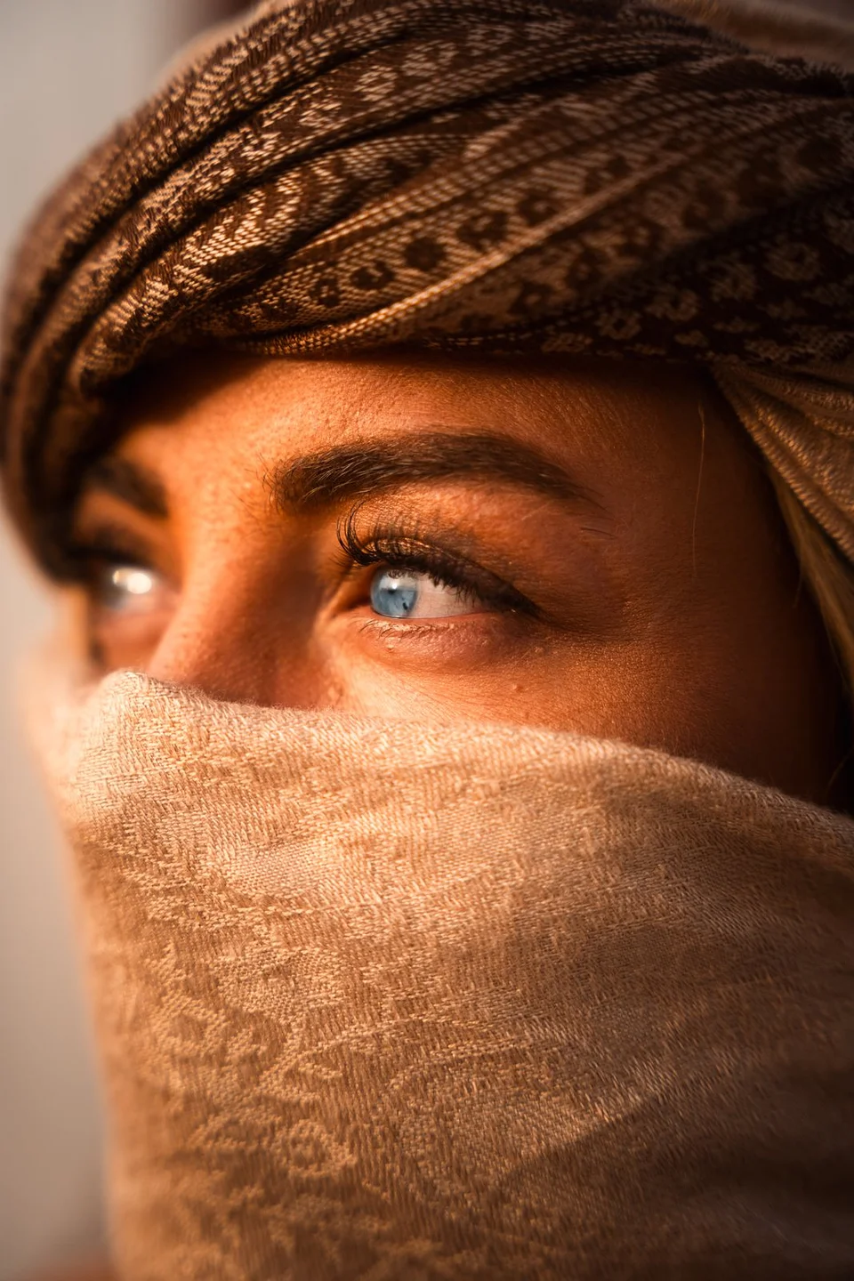 A close portrait of a traveler wearing a desert face scarf