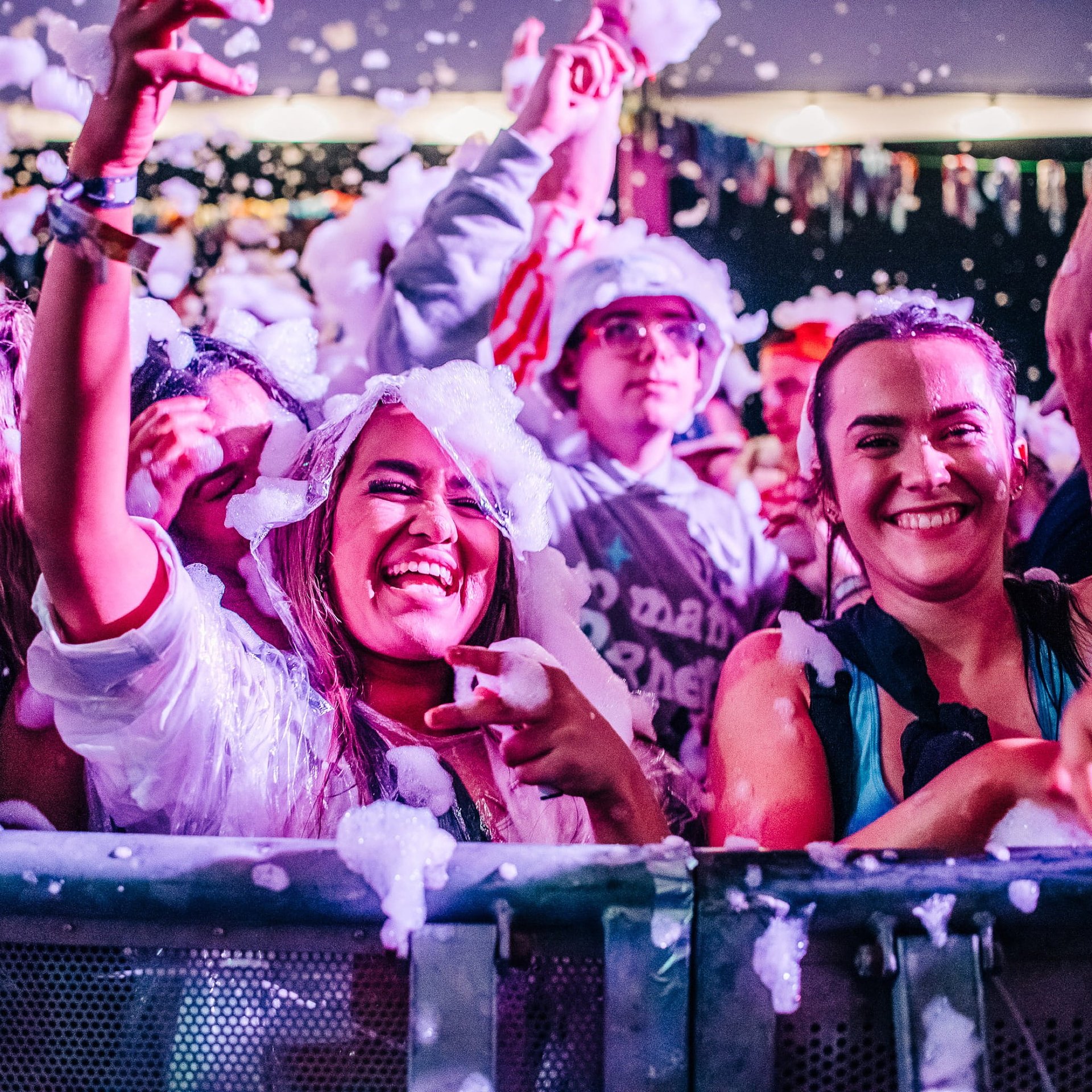 Festival goers dance and smile at the front row of the Beer Tent to the music during the foam party at Bournemouth 7s Festival in Dorset