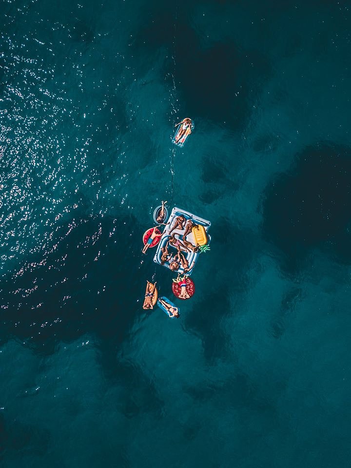areal shot of people on floaties in the ocean croatia ultra europe