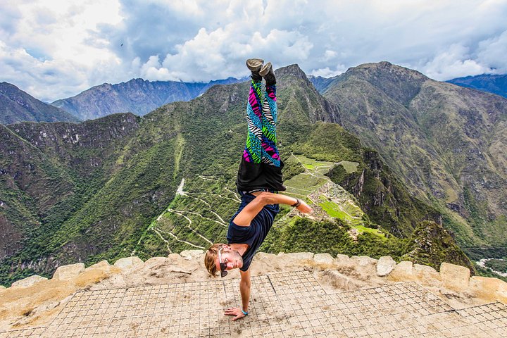 man doing 1 hand handstand at machu picchu peru holidays