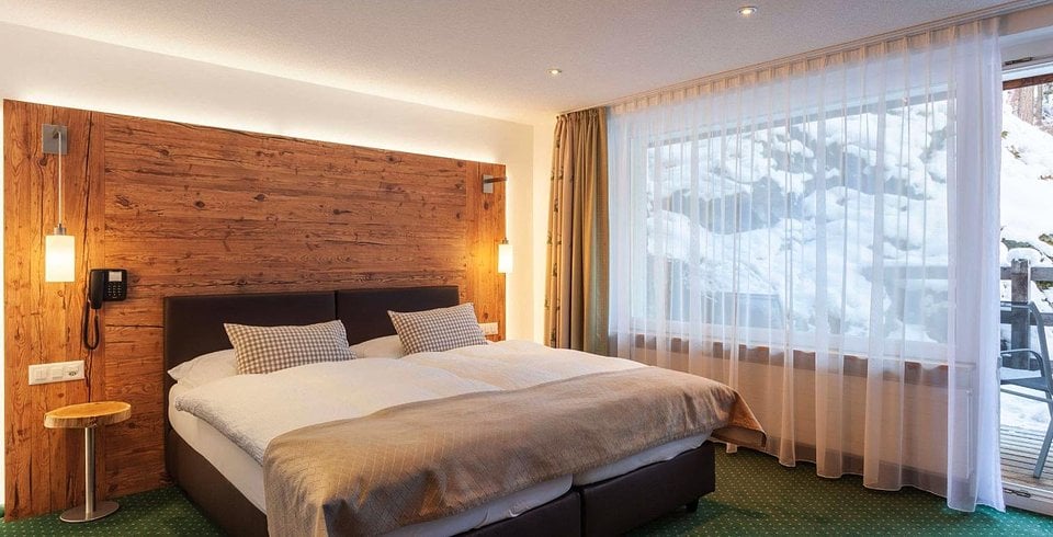 A twin room with a balcony at Hotel Jagerhof in Zermatt
