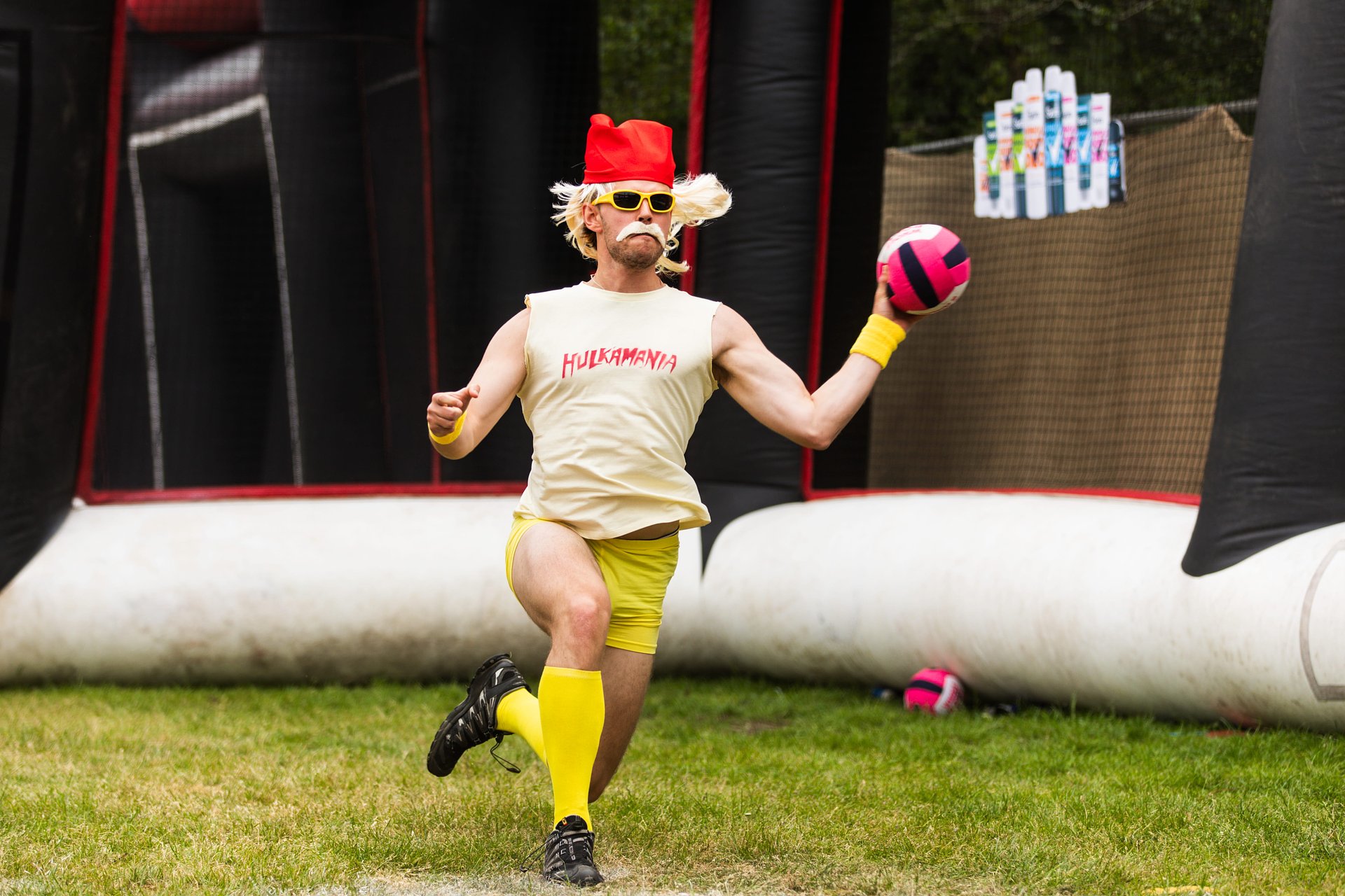 Dodgeball player in fancy dress as Hulk Hogan with Hulkmania written on his chest throws a ball at Bournemouth 7s Festival, in Dorset.