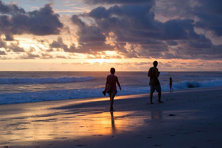 people walking down the beach at sunset in santa teresa costa rica vacation packages