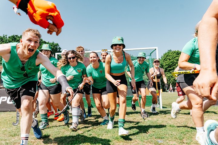 Mixed hockey team running towards the camera celebrating after a tournament at Bournemouth 7s Festival, in Dorset England.