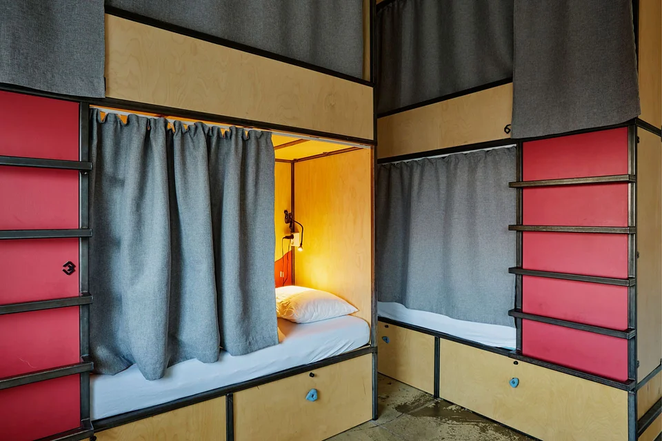 A shared room with a curtain on every bunk at Midgard Base Camp