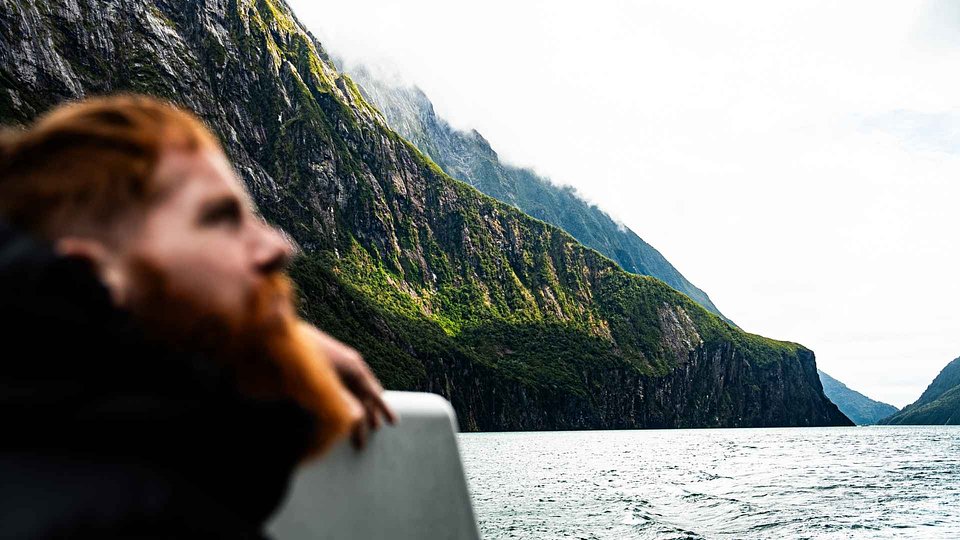 Russ Cook looking out over a fjord from a boat