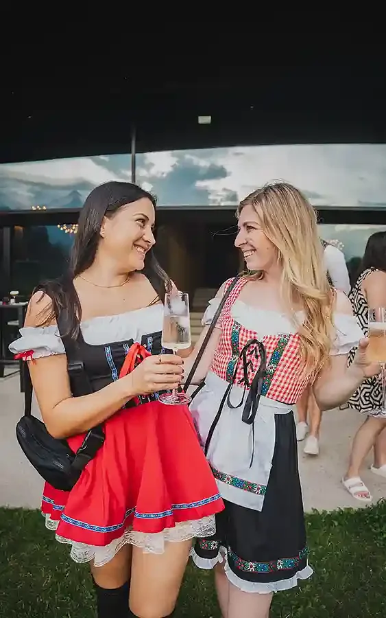 Two women in dirndls laughing in the Dolomites