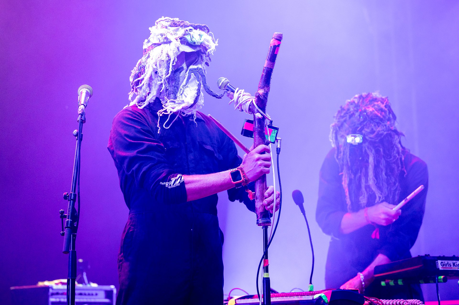 Band Snapped Ankles performing. Two men on the stage wearing masks that cover their head made of white fur