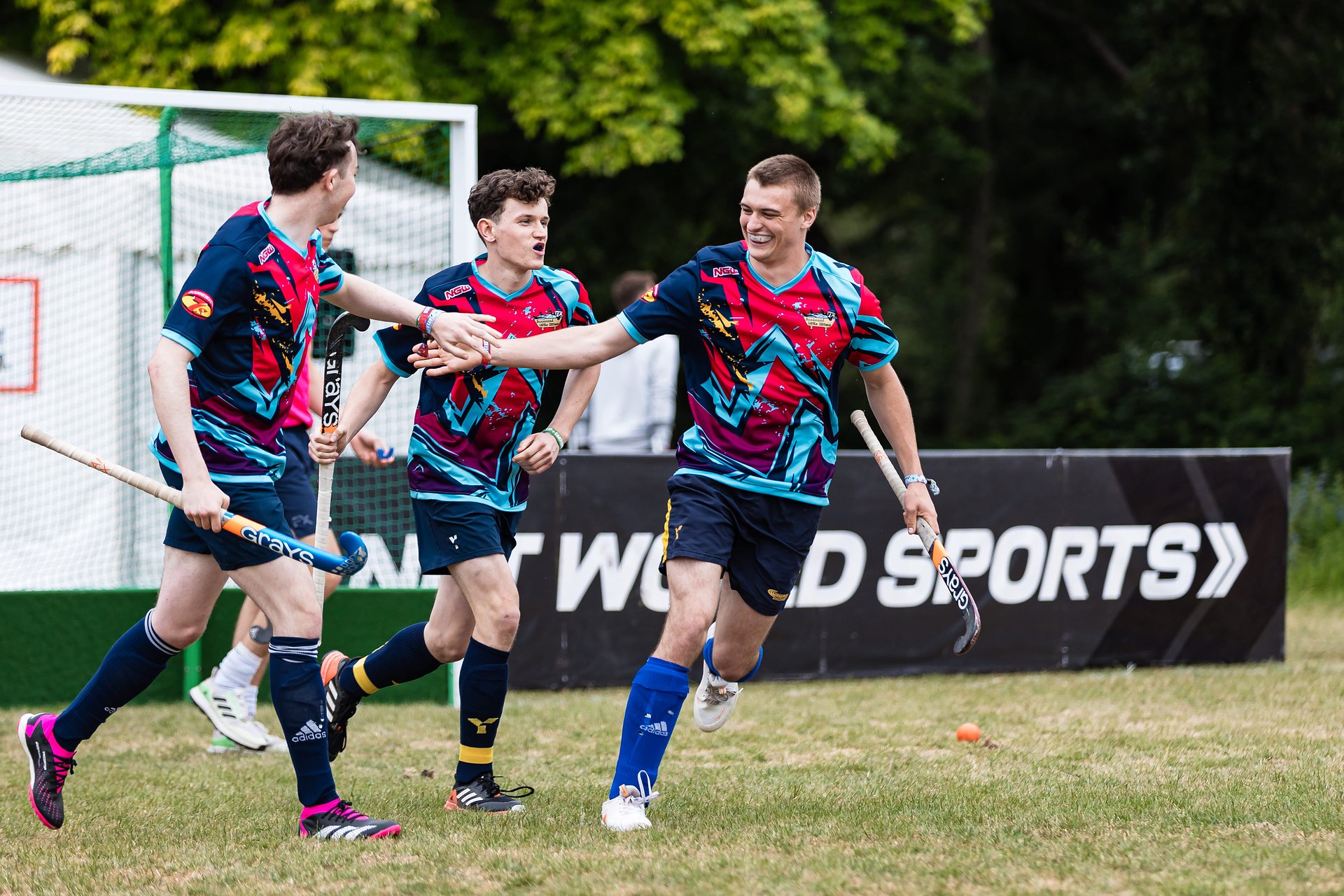 Mens hockey team celebrate with each other after scoring during a hockey tournament at Bournemouth 7s Festival, in Dorset England.
