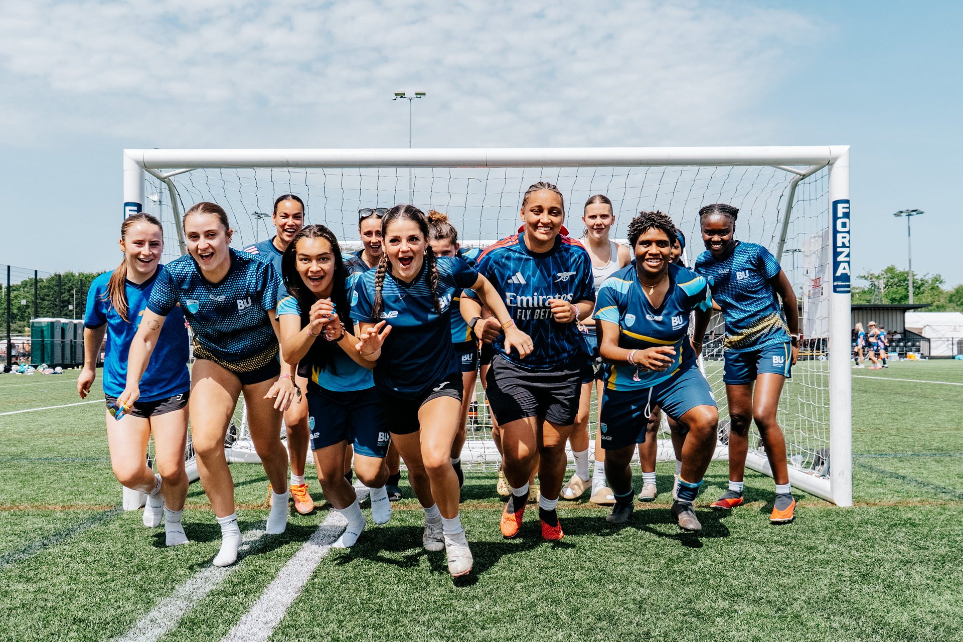 Women's football team run towards the camera after a 6-a-side tournament at Bournemouth 7s Festival, in Dorset England