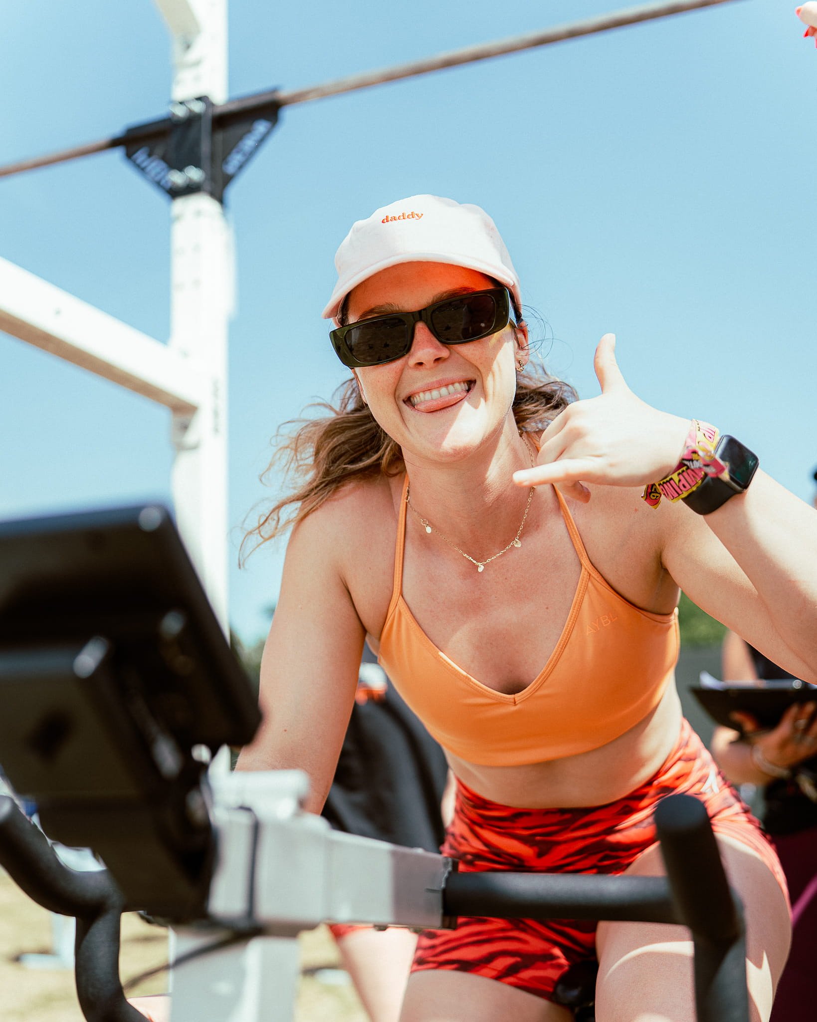 Girl competing in the annual Fitness Games workouts on a bike at Bournemouth 7s Festival, based in Dorset.