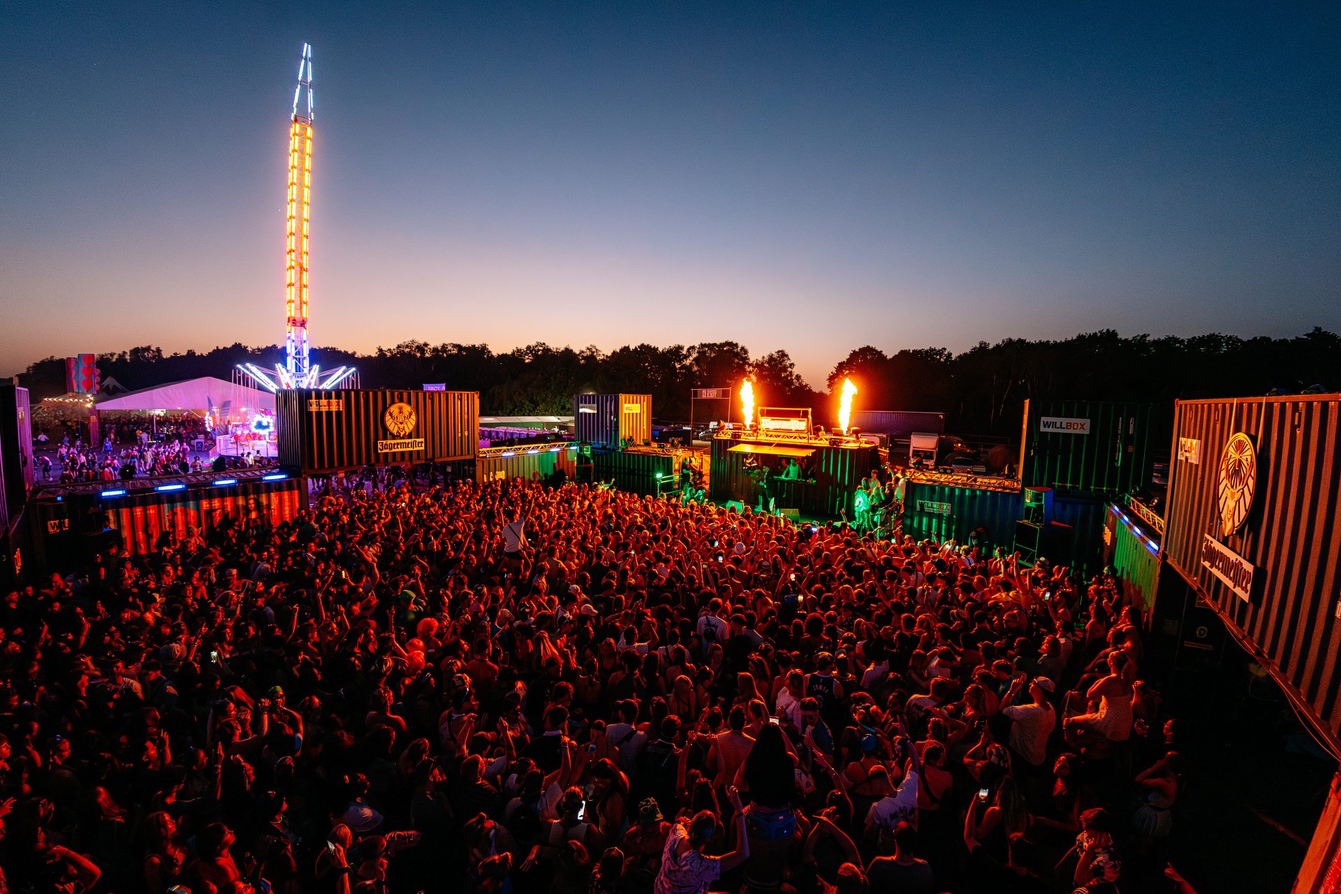Aerial shot of the Bunker stage with a large outdoor crowd surrounded by shipping containers, flame cannons, with live MCs, DJs all hosted by Jägermeister, at Bournemouth 7s Festival in Dorset. 