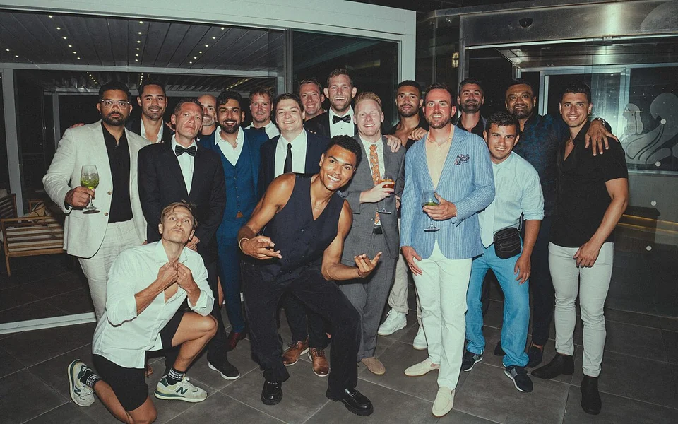 An SYB group in black tie by the sea at night