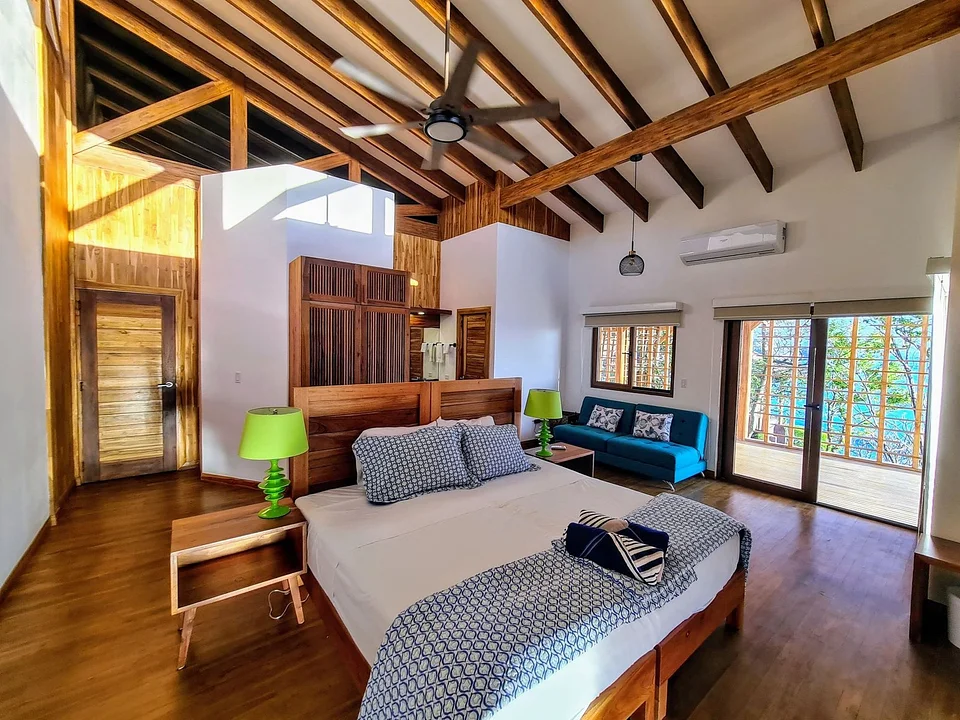 A bedroom with a vaulted wooden ceiling at Villas Playa Maderas
