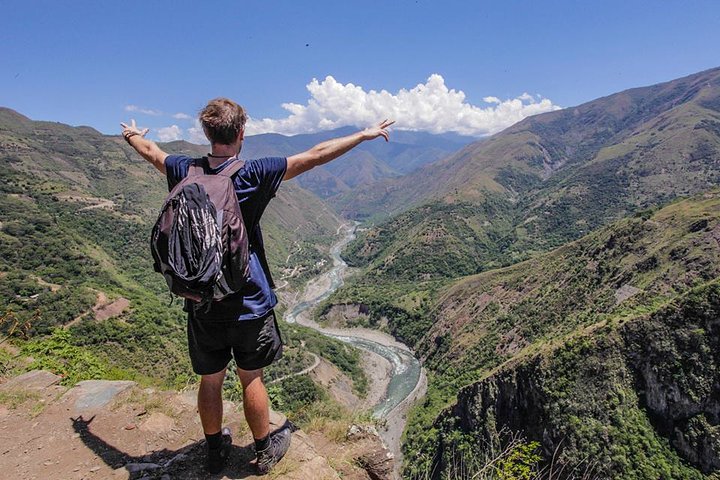 traveller with his arms up overlooking the sacred valley cusco peru tourism