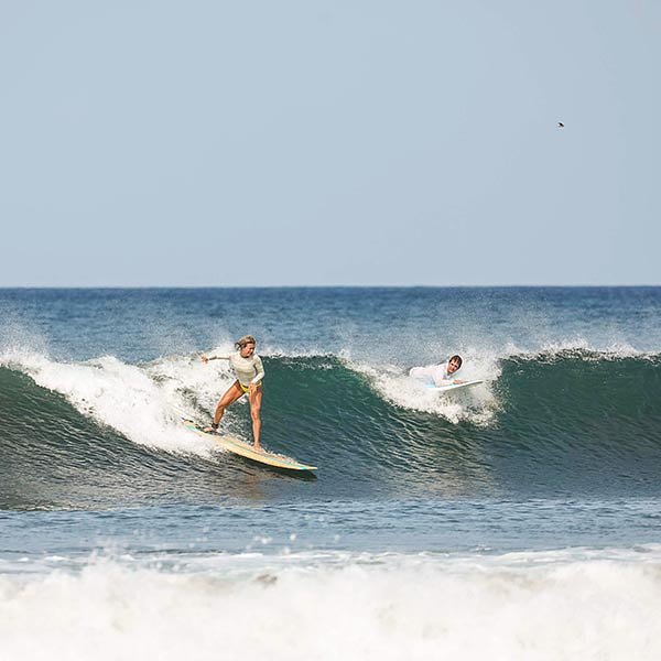 Two surfers riding a wave in Nicaragua_travel South America