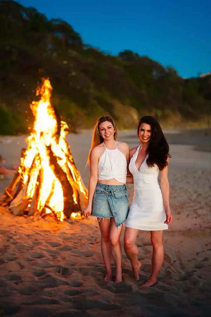 Two women by the beach bonfire at night