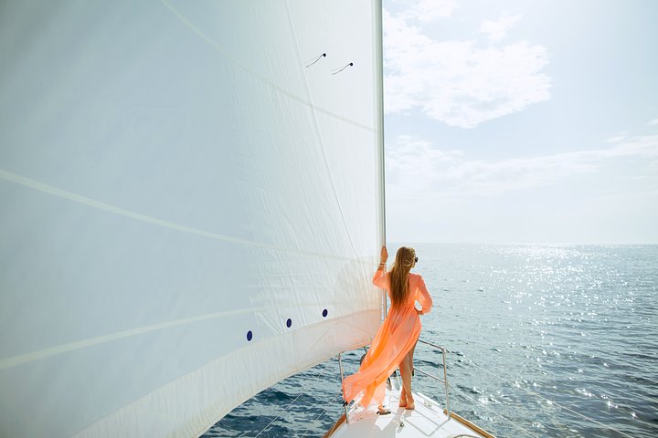womaninsarongyachtingwhitesailsluxurytravelVKMMD8Q