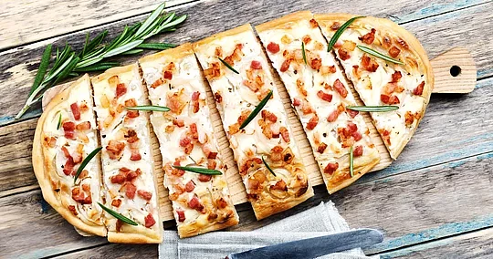 Savoring a traditional tarte flambée, an Alsatian style pizza