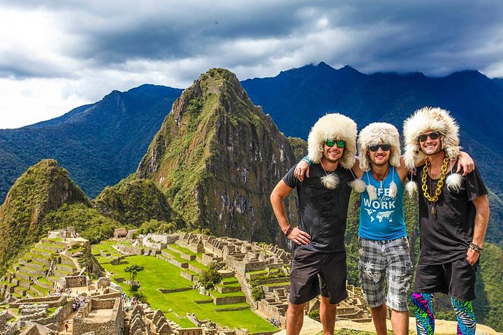 3 guys wearing alpaca hats at machu picchu smiling group tours peru travel