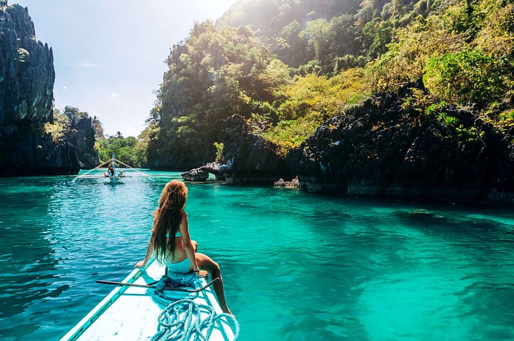 girl sitting at the edge of a long boat in east philippines islands