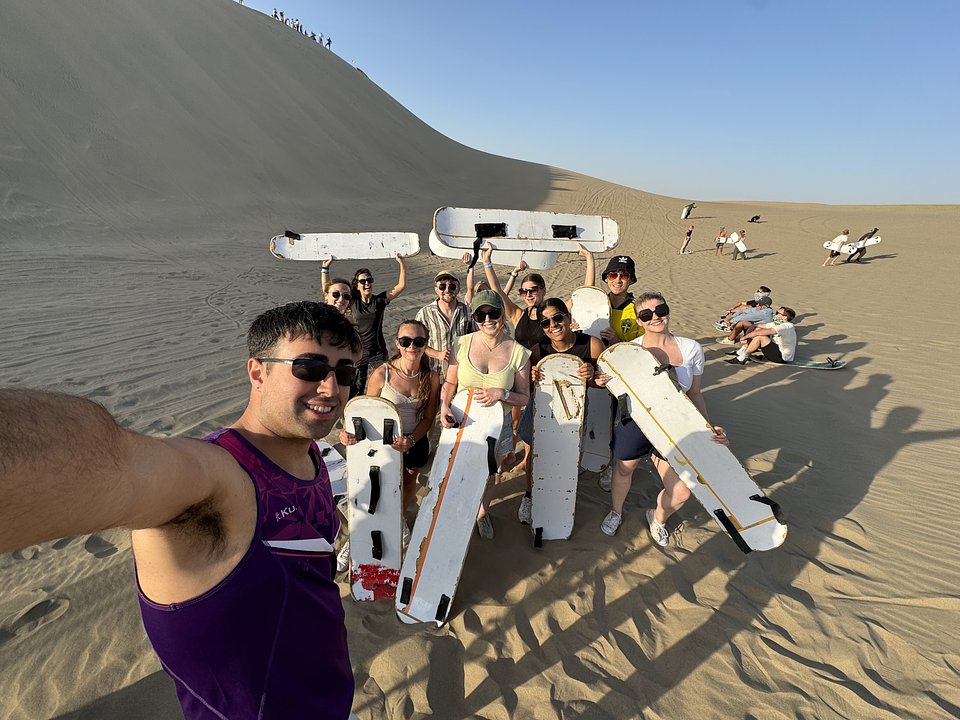 Group selfie with sandboards on the dunes at Huacachina