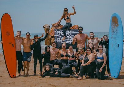 SurfYogaBeer crew celebrating on a rooftop at dusk in Morocco