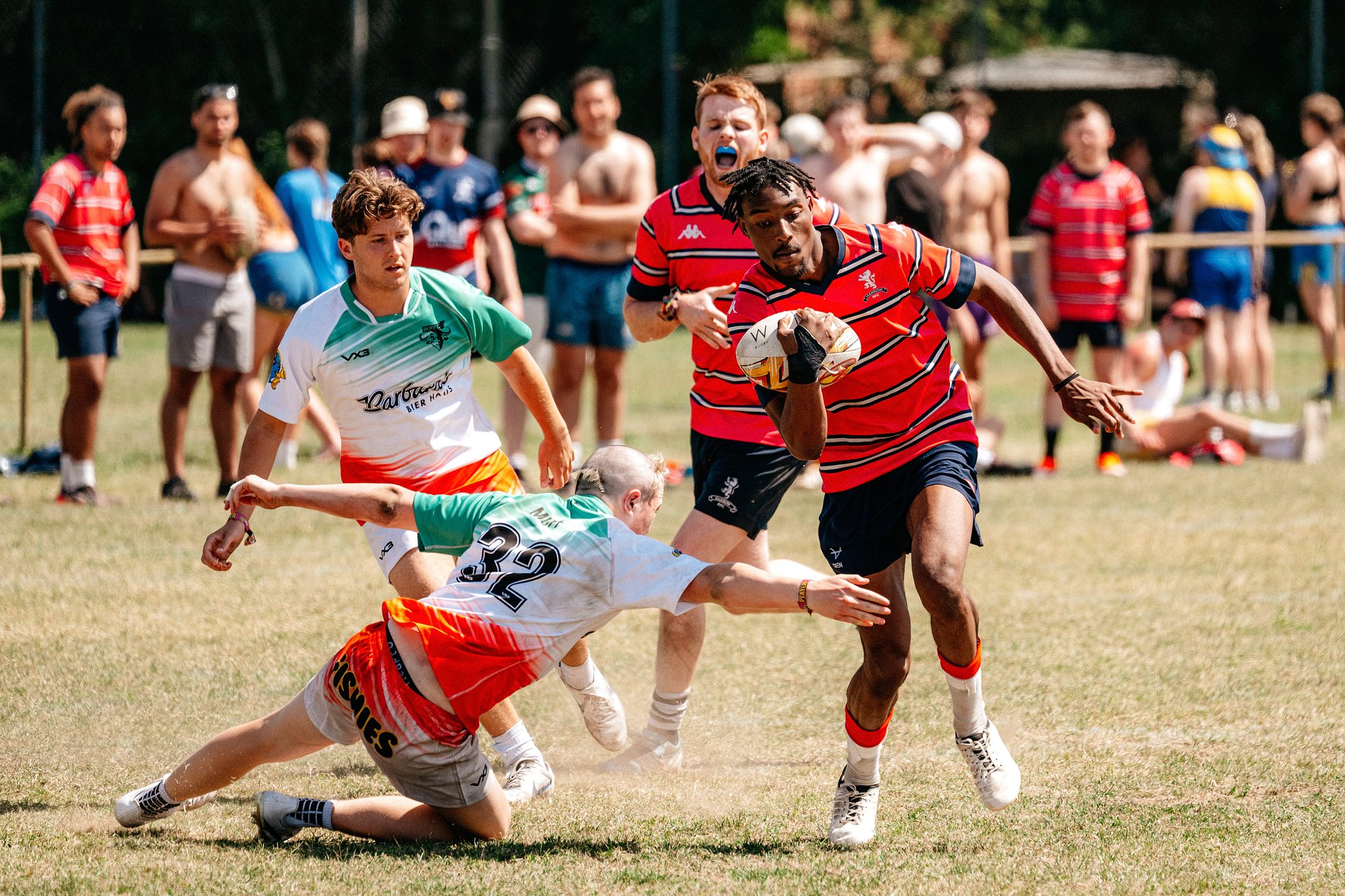 Men’s rugby action at Bournemouth 7s Festival in Dorset, with a player carrying the ball as an opponent attempts a tackle.